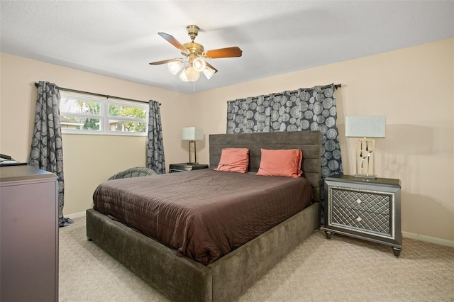 bedroom featuring light colored carpet, baseboards, and ceiling fan