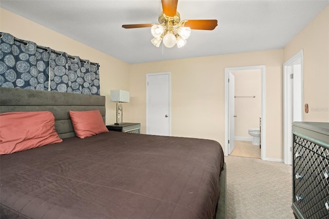 bedroom featuring ceiling fan, ensuite bath, baseboards, and light carpet