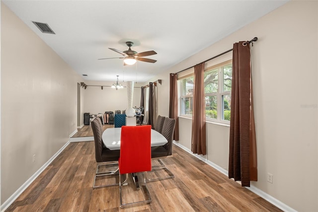 dining space featuring ceiling fan, visible vents, baseboards, and wood finished floors