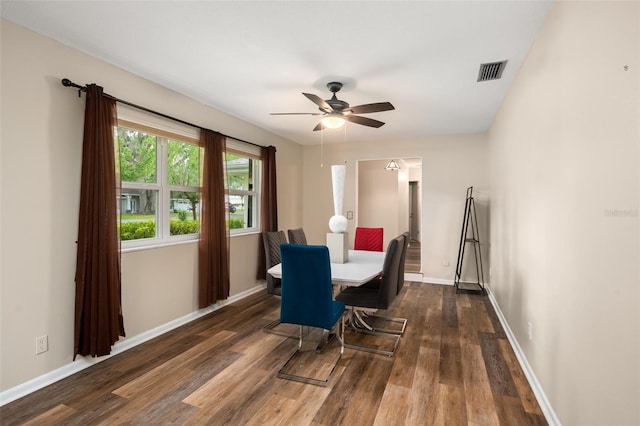 dining room featuring dark wood-style floors, visible vents, baseboards, and a ceiling fan