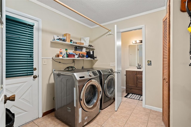 clothes washing area with ornamental molding, laundry area, light tile patterned flooring, a textured ceiling, and separate washer and dryer