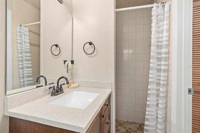 full bathroom featuring vanity and tiled shower