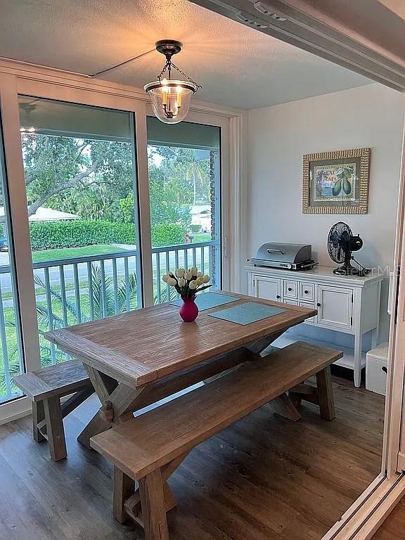 dining space with a textured ceiling and wood finished floors