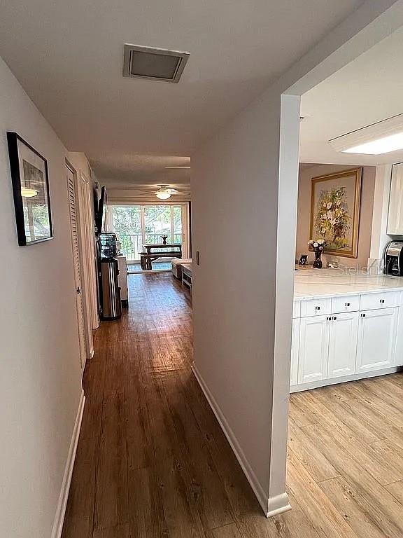 corridor featuring baseboards and wood finished floors