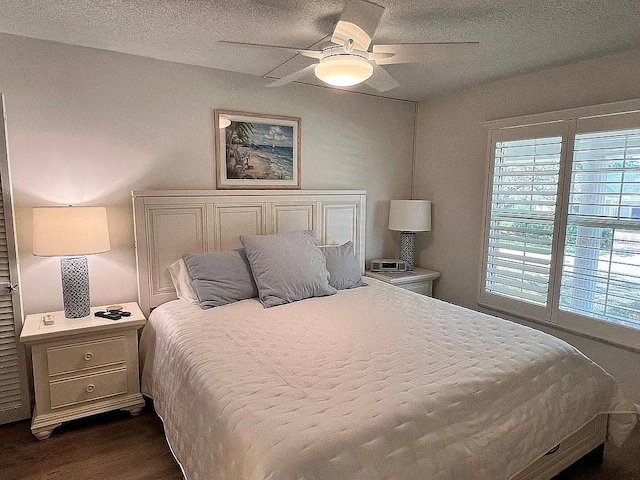 bedroom with a ceiling fan, dark wood-style floors, and a textured ceiling