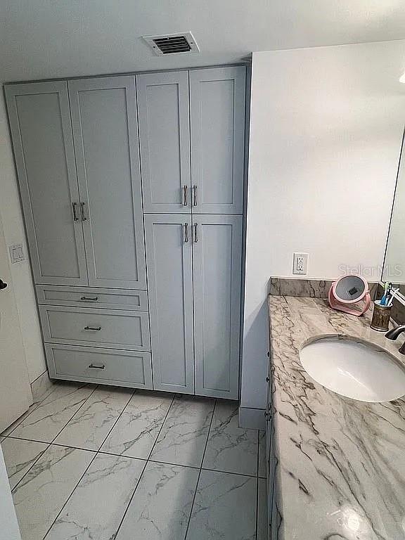 bathroom with visible vents, marble finish floor, and vanity