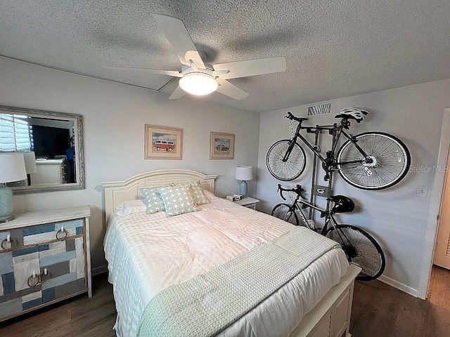 bedroom with visible vents, baseboards, a textured ceiling, and dark wood-style flooring