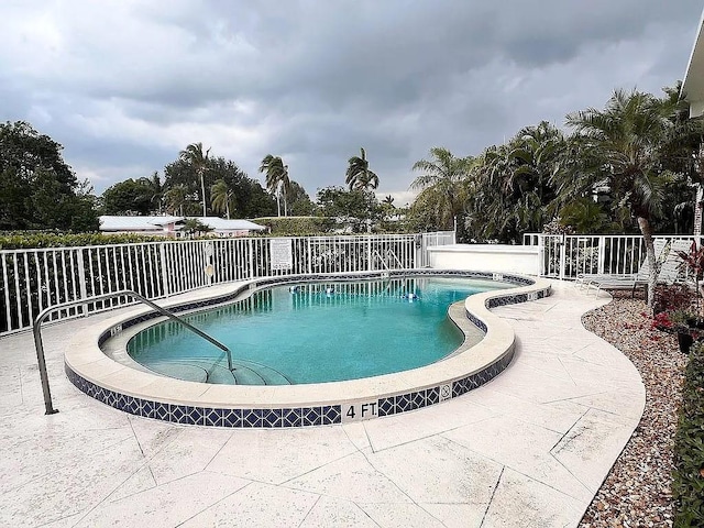 community pool with fence and a patio area