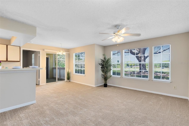 unfurnished living room featuring baseboards, light carpet, and a textured ceiling
