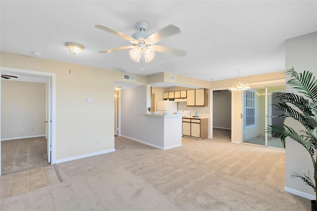 living area featuring visible vents, ceiling fan with notable chandelier, a textured ceiling, and light colored carpet