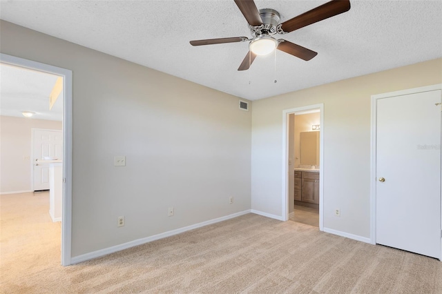 unfurnished bedroom with visible vents, baseboards, light colored carpet, and a textured ceiling