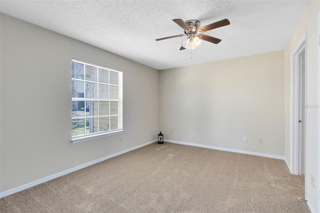 carpeted spare room with baseboards, a textured ceiling, and a ceiling fan
