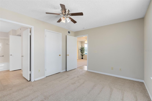 unfurnished bedroom featuring visible vents, a textured ceiling, baseboards, and carpet floors