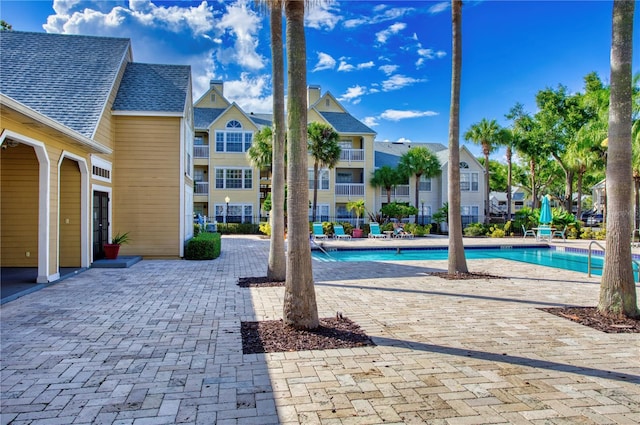 pool with a residential view and a patio