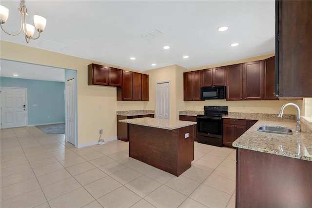 kitchen with a center island, light tile patterned floors, light stone counters, black appliances, and a sink