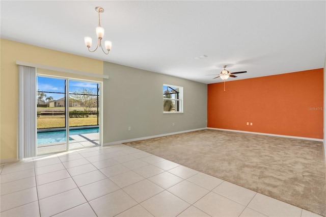 unfurnished room with light carpet, light tile patterned floors, ceiling fan with notable chandelier, and baseboards