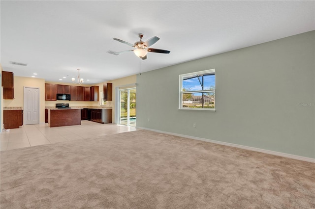 unfurnished living room featuring light tile patterned floors, visible vents, light carpet, and ceiling fan with notable chandelier