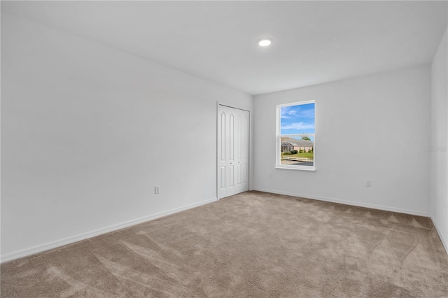 carpeted spare room featuring baseboards