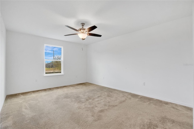 empty room with baseboards, ceiling fan, and carpet flooring