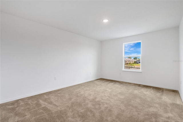 spare room with baseboards and carpet floors