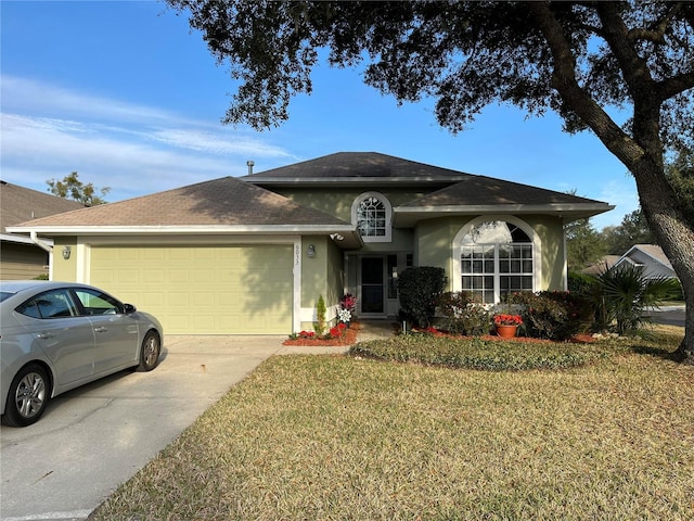 ranch-style home with stucco siding, driveway, a front yard, and an attached garage