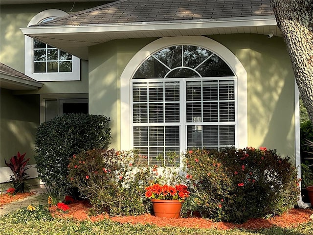 exterior details with stucco siding and a shingled roof