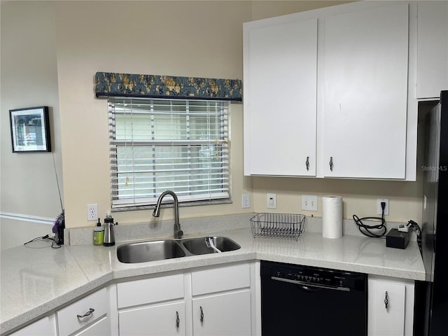 kitchen with white cabinets, black appliances, light countertops, and a sink