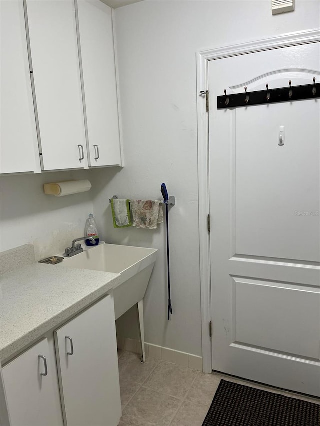 laundry room with light tile patterned floors and baseboards