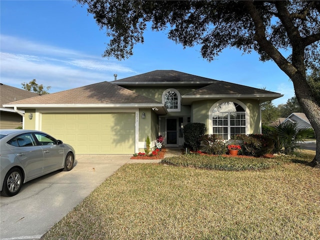 single story home with an attached garage, a shingled roof, a front yard, and stucco siding