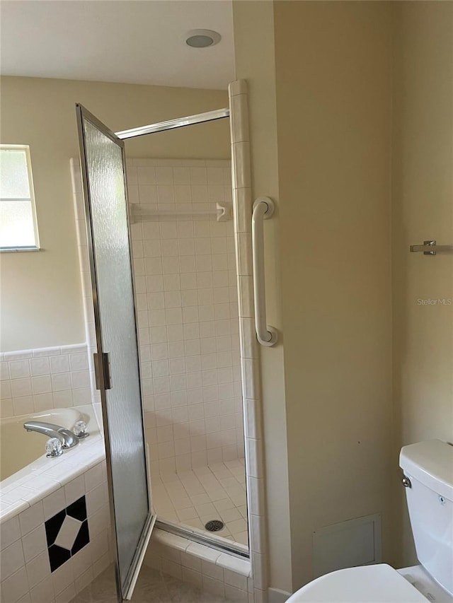 full bathroom featuring toilet, a garden tub, and a stall shower