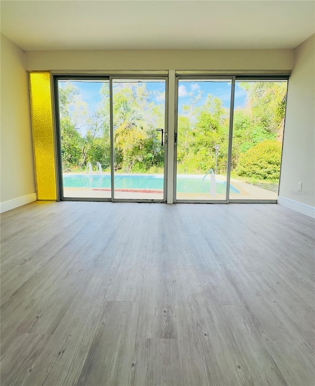 unfurnished living room featuring baseboards and wood finished floors