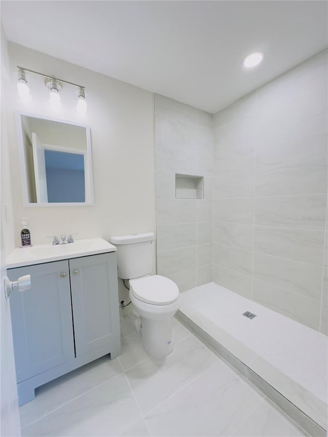 bathroom with vanity, recessed lighting, a tile shower, toilet, and marble finish floor