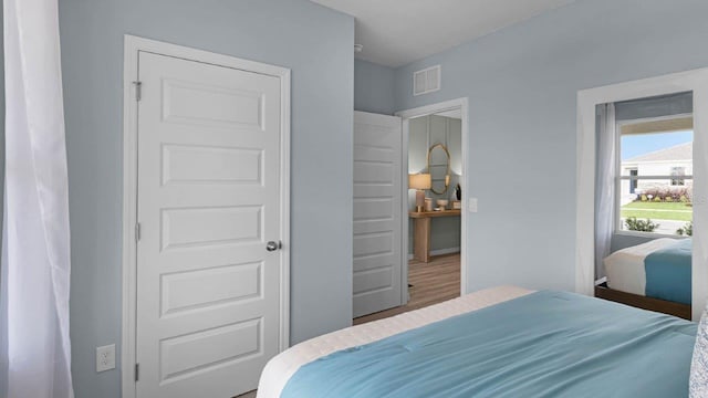 bedroom featuring wood finished floors and visible vents