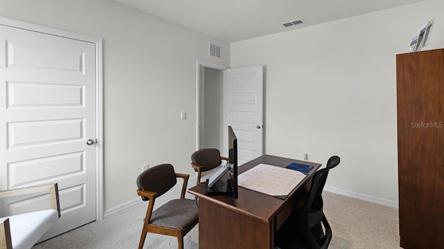 office area with baseboards, visible vents, and light carpet