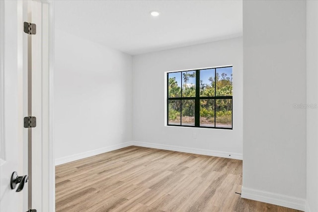 unfurnished room featuring recessed lighting, wood finished floors, and baseboards