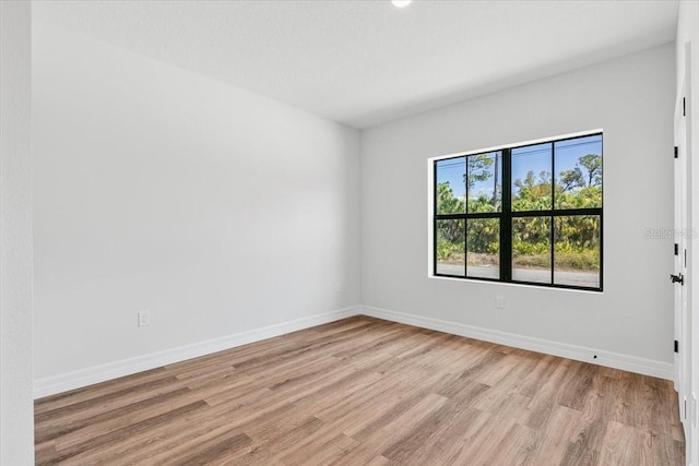 unfurnished room with baseboards and light wood finished floors