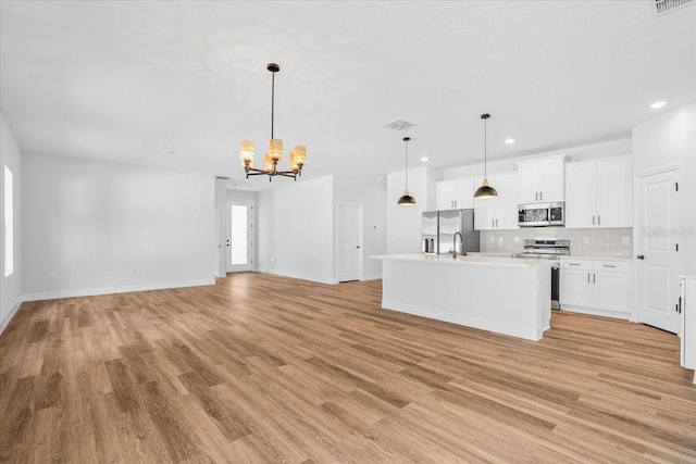 kitchen with visible vents, backsplash, appliances with stainless steel finishes, light countertops, and a chandelier