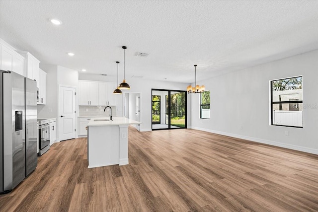 kitchen featuring a chandelier, wood finished floors, appliances with stainless steel finishes, and a sink