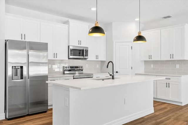 kitchen featuring wood finished floors, stainless steel appliances, visible vents, and a sink