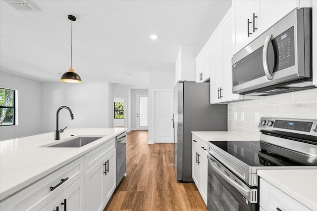 kitchen with a sink, decorative backsplash, appliances with stainless steel finishes, and light countertops