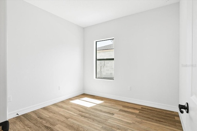 empty room with baseboards and wood finished floors