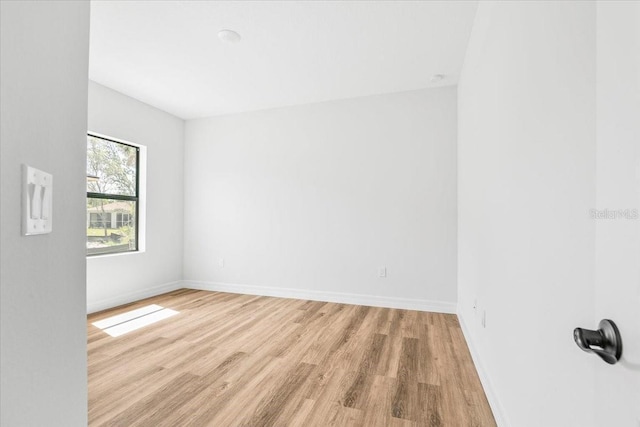 unfurnished room featuring baseboards and light wood finished floors