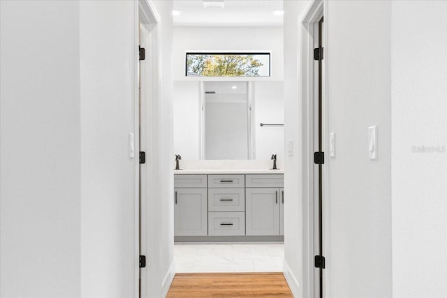 hall featuring light wood-type flooring and a sink