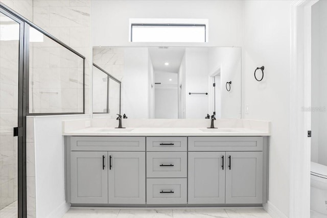 full bath with a sink, toilet, marble finish floor, and a stall shower