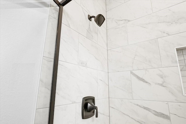 interior details featuring a tile shower