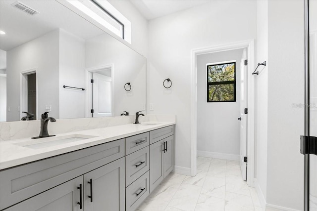 full bathroom with visible vents, marble finish floor, baseboards, and a sink