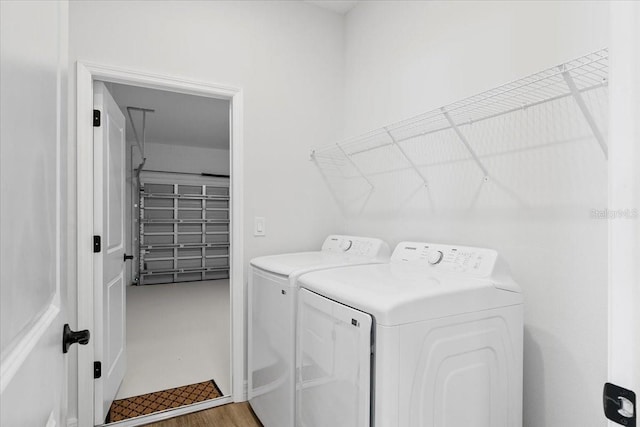 clothes washing area featuring laundry area, separate washer and dryer, and light wood-type flooring