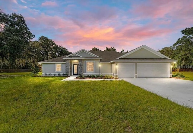 single story home with stucco siding, a lawn, an attached garage, and driveway