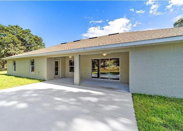 rear view of property featuring stucco siding, a carport, and a patio area