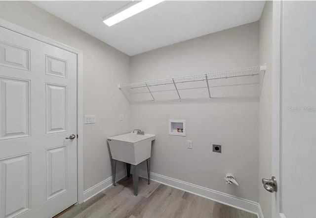 clothes washing area featuring hookup for a washing machine, baseboards, laundry area, light wood-style flooring, and electric dryer hookup